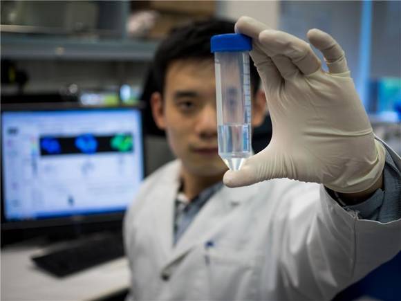 NTU researcher Li Liang holding the new antibody which can help patients suffering from pneumonia and influenza to recover faster. Ⓒ Image courtesy of Nanyang Technological University