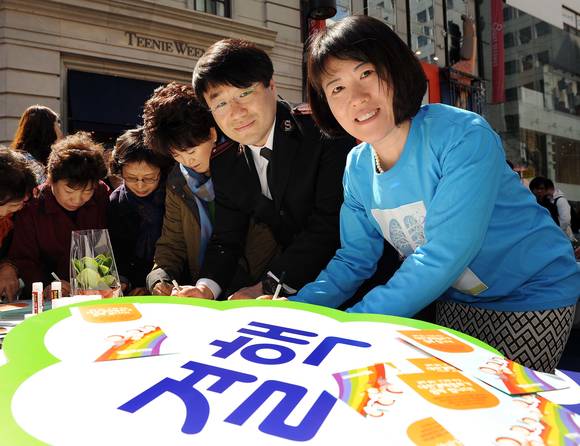 한국얀센 김옥연 대표이사(오른쪽)와 구세군 관계자가 서울 명동예술극장 앞에서 시민들과 함께 결핵 예방과 인식향상을 위한 ‘Lung Tree Care’ 캠페인을 응원하는 메시지를 작성하고 있다.