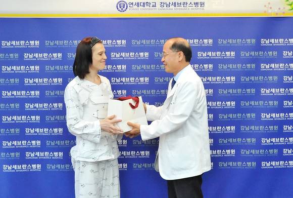김형중 강남세브란스병원장이 카자흐스탄 환자 타티아나에게 퇴원 축하 선물을 건네고 있다