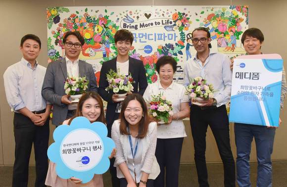 23일(목) 한국먼디파마 창립 17주년 기념 희망꽃바구니 행사에서 습윤드레싱재 메디폼® 홍보 모델 이승기가 먼디파마 한국 및 동남아시아 총괄 이종호 사장을 비롯한 한국먼디파마 임직원들과 함께 소아암 환자 가족들에게 전달할 꽃바구니와 선물을 들고 기념 촬영에 참여했다.