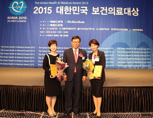 유경하 이대목동병원장(사진 왼쪽)과 이향운 이대목동병원 수면센터장(사진 오른쪽)이 시상식에서 김춘진 국회 보건복지위원장과 기념 촬영을 하고 있다.