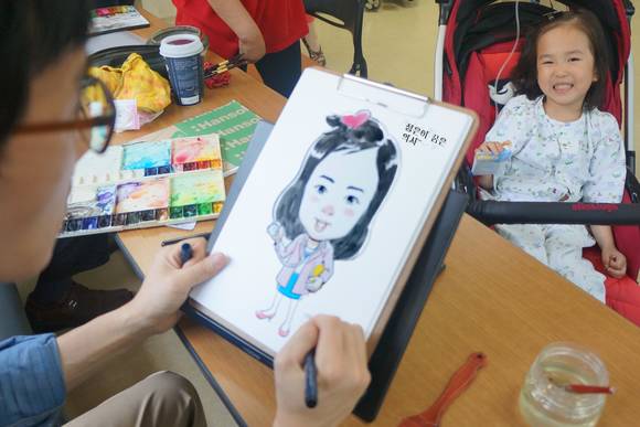 “정은이의 꿈은 의사~”. 만화작가가 부천성모병원 소아병동에 입원하고 있는 의사가 꿈인 소아 환아의 캐리커처를 그리고 있다.