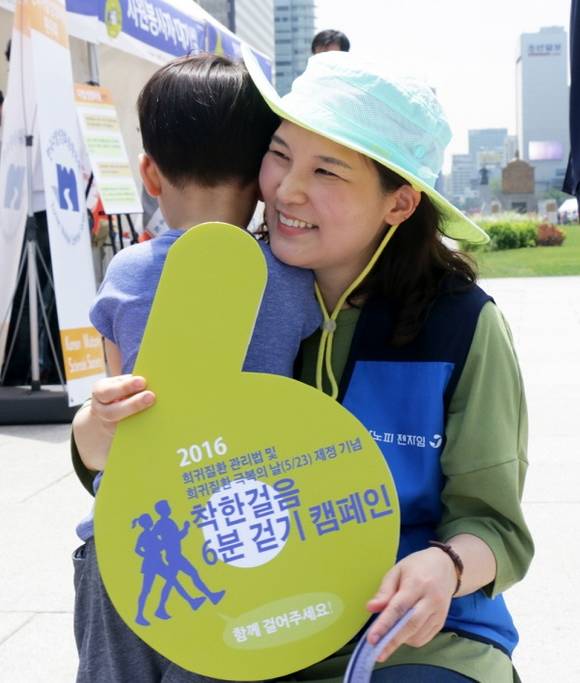 ‘착한걸음 6분 걷기 캠페인’을 완주한 아들을 꼭 안아 주고 있는 사노피 젠자임 의학부 김석란 이사.