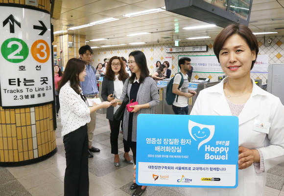 무료 건강상담과 건강강좌를 진행하는 교대역 ‘스마트로’ 앞에서 ‘양보카드’ 이미지와 화장실 배려 캠페인 문구를 넣은 지하철 노선도를 배포하고 있다.