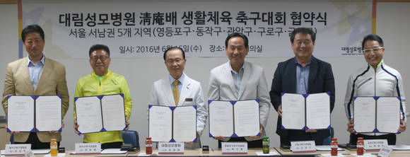 대림성모병원 김광태 이사장(왼쪽에서 세번째)과 5개 구 축구연합회 대표가 기념 촬영을 하고 있다.