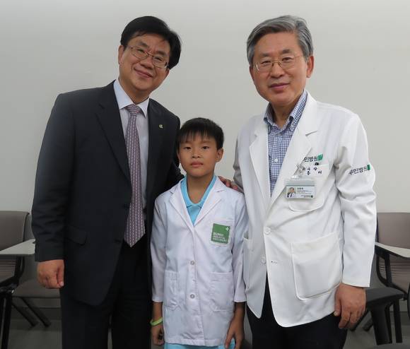 의사가 꿈인 베트남 결연 아동 은우엔 띠엔 팟(남, 13세)과 어린이 의사 가운 전달 후 기념사진(우, 부민병원 정흥태 이사장 / 좌, 기아대책 유원식 회장)