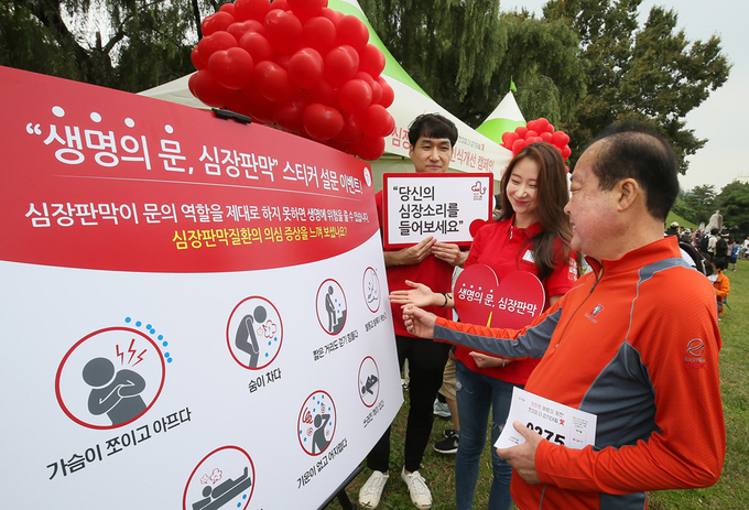 에드워즈라이프사이언시스코리아 임직원들이 한국심장재단이 개최한 ‘2017 심장병 예방을 위한 한걸음 더 걷기대회’에 ‘당신의 심장소리를 들어보세요’ 캠페인 홍보 부스를 마련하고 심장판막질환을 의심해 볼 수 있는 경고증상에 대해 시민에게 설명하고 있다. (사진제공 에드워즈라이프사이언시스코리아)