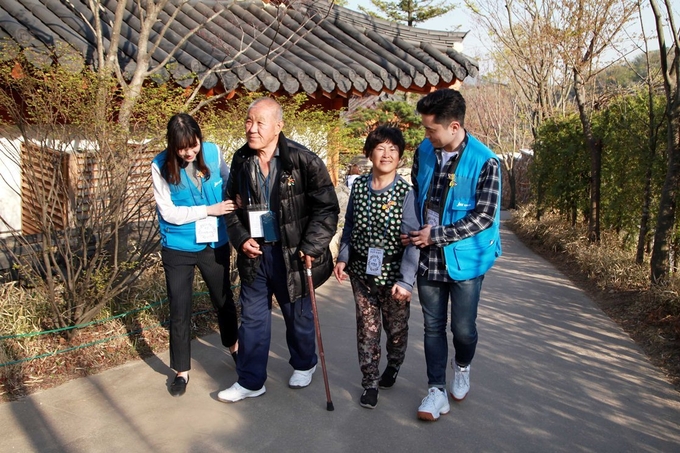 ‘JW중외 한마음봉사단’ 직원들이 거동이 불편한 독거어르신들과 함께 경기도 광주 화담숲을 산책하고 있다.