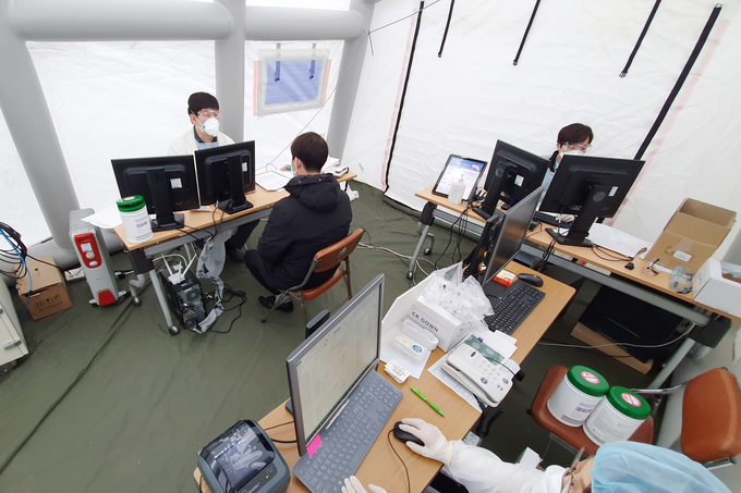 감염내과 최재기 교수가 선별진료소에서 코로나바이러스감염증-19 감염여부를 걱정하고 내원한 호흡기환자를 진료하고 있다. 선별진료실에는 감염위험을 낮추고 환자에게 편의성을 제공하고자 원무수납까지 바로 진행할 수 있도록 원무팀이 상주하여 환자의 동선을 최소화하고 있다.