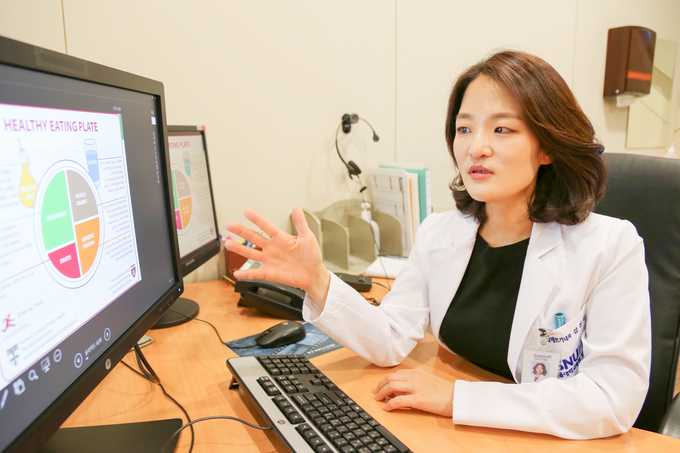 김선신 교수가 라이프스타일 코칭클리닉에서 환자에게 건강한 생활습관의 중요성을 설명하고 있다