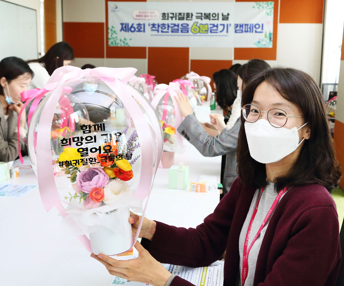 맞이해 5월 21일에 제6회 착한걸음 6분걷기 캠페인에 참여 하기 위해 희망풍선에 희귀질환 환자 응원 메시지를 새기고 있다.