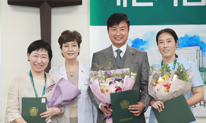 유경하 이화의료원장이 최수전 보험심사팀장 등 표창 수상자와 기념 사진을 찍고 있다.