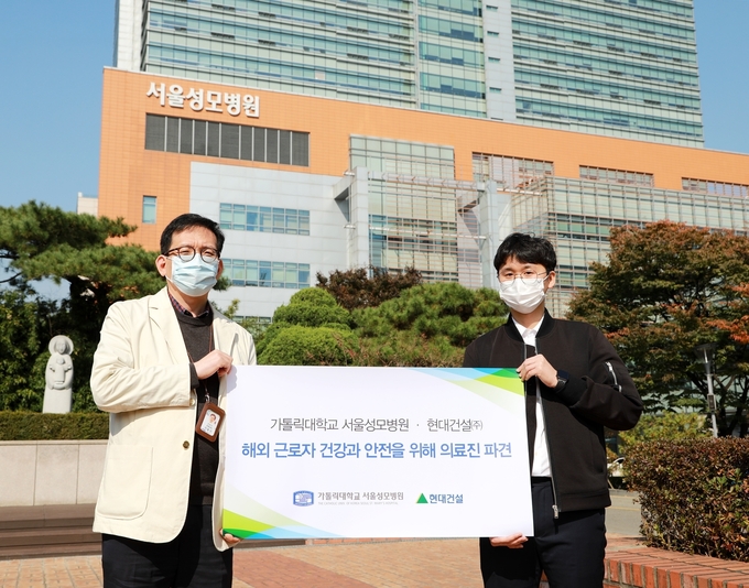 코로나19로 인한 해외 근로자의 건강과 안전을 위해 이라크 현지에 파견되는 이동건 교수와 강재진 간호사가 출국 전 병원 앞에서 기념사진을 찍었다.