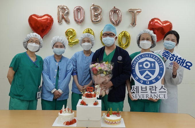 두경부암 로봇수술 단독 2,000례를 달성한 고윤우 교수(왼쪽에서 네 번째)가 기념사진을 촬영하고 있다.
