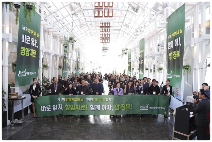 제 1회 항암치료의 날 기념행사에 참석한 내빈과 참석자가 암 극복 다짐을 위한 구호를 외치고 있다. 